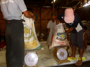 Staff at the ration's storeroom measure rice